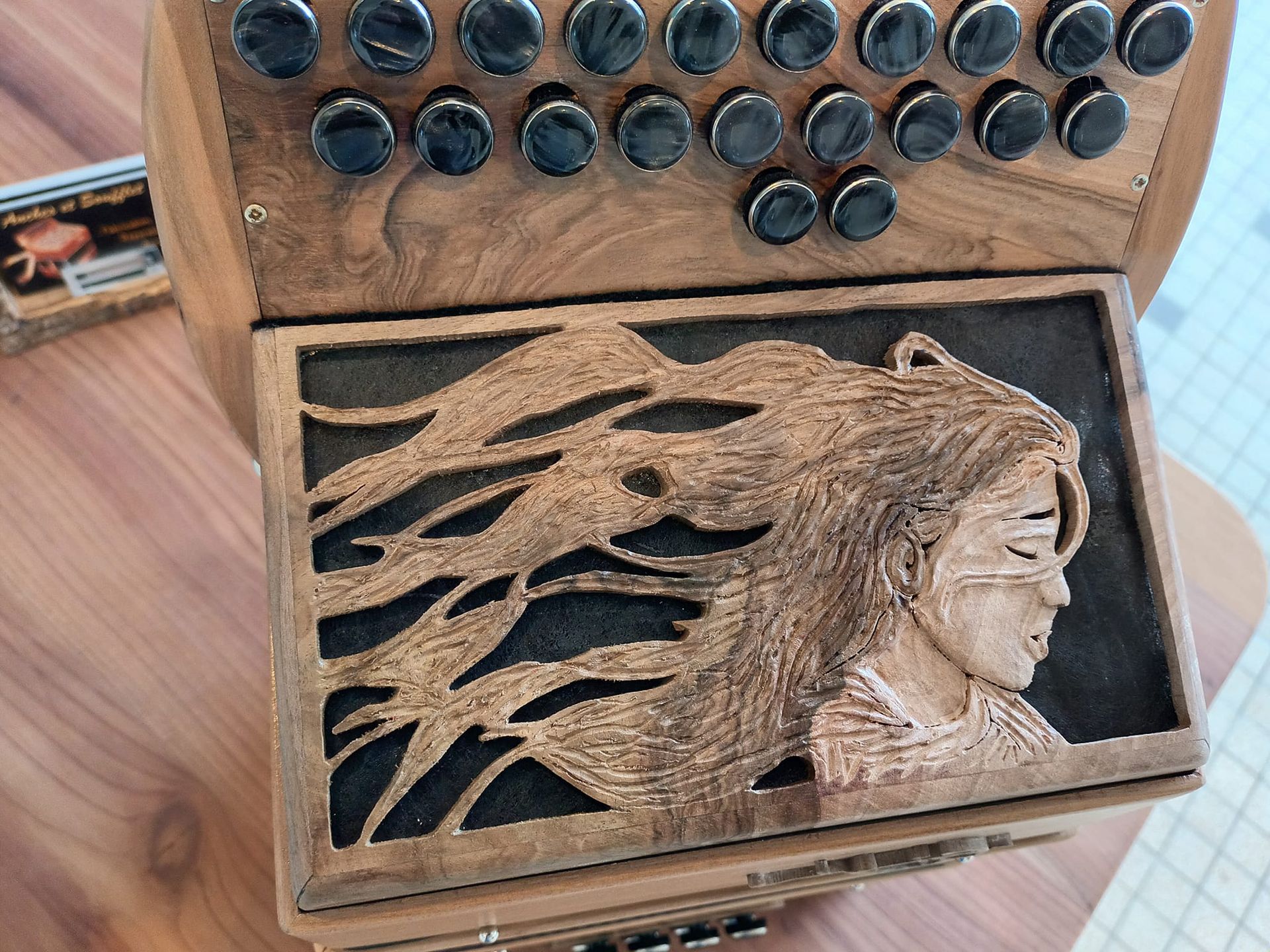 Grille d'accordéon suclptée en fonction des veines du bois Grille d'accordéon diatonique - Sculpture d'une fille les cheveux dans le vent